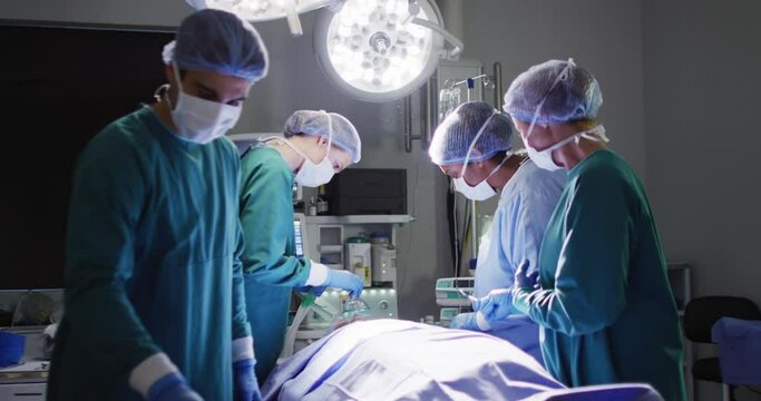 Video of diverse group of surgeons operating on patient in operating theatre