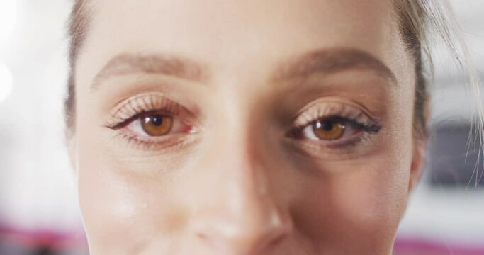 Close up video portrait of hazel eyes of happy caucasian woman with blonde hair smiling to camera