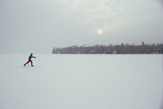 A person cross country skiis on a frozen lake.
