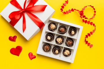 Delicious chocolate pralines in red box for Valentine's Day. Heart shaped box of chocolates top view with copy space