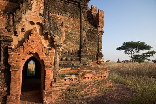 A group of 13th-century pagodas of varying sizes stand among farm fields lining the shores of the Irrawaddy river at Bagan, Union of Myanmar (Burma)