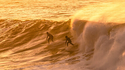 Surfers being catched by a massive wave