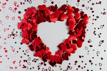 Heart shape made of red hearts on white background. Decoration for Valentine's day. Overhead view.