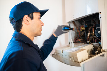 Smiling technician repairing an hot-water heater