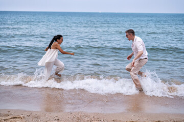 Fototapeta na wymiar Love couple on holiday happy playing running along the beach and sweet kiss on love emotion