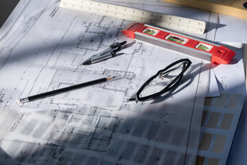 Architect concept, Architects working with blueprints in the office Business accessories (laptop, smartphone, pens, magnifier), accessories for drawing (plans, rulers) and learning on the table