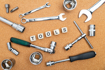 wrenches near the cubes with the inscription TOOLS on the cork table. View from above.