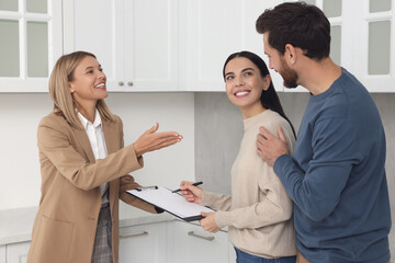 Real estate agent and couple signing contract in new apartment