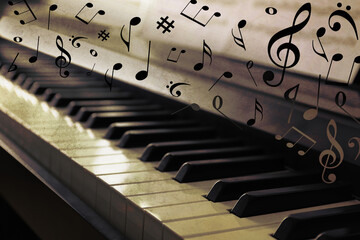 Music notes and other musical symbols over piano, closeup. Vintage effect