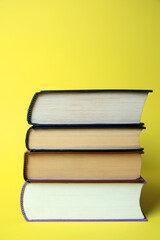 Collection of hardcover books on yellow background