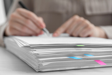 Woman signing documents at wooden table in office, closeup. Space for text