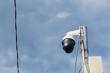 selective focus to black cctv camera on clear sky background