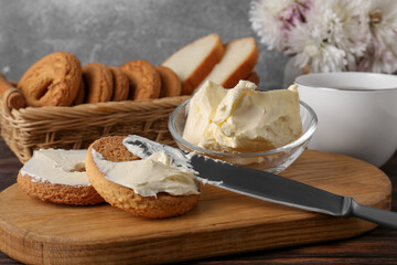 Tasty homemade butter, cookies and cup of tea on wooden table, closeup