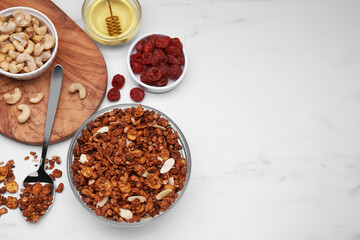 Obraz na płótnie Canvas Tasty granola with nuts and dry fruits on white marble table, flat lay. Space for text