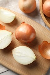 Whole and cut onions on table, flat lay