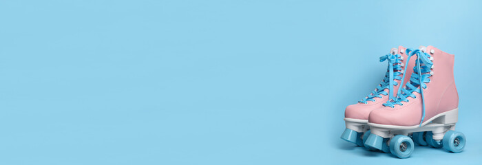 Pair of stylish quad roller skates on light blue background, space for text. Banner design