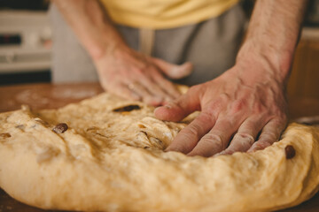 men's hands knead the dough