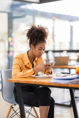 Busy young business woman eating a Thai food lunch while working at workplace. A working woman...