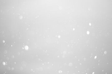 White glitter vintage lights background.  White bokeh shiny on dark background.