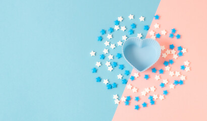 Muffin heart shape and candy sprinkles on pink and blue.