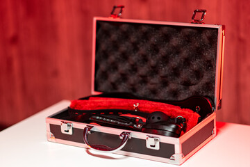 Sex toys for adults in a box. Suitcase with sex toys in black and red