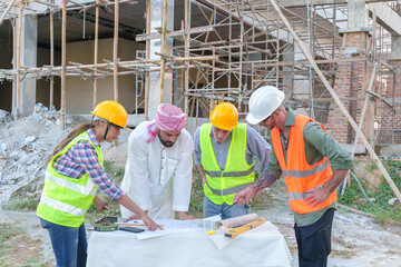 Diverse team of professionals using tablet computers on construction site. Real estate construction project. with civil engineers, architects, Arabic business investors and explorer with theodolite