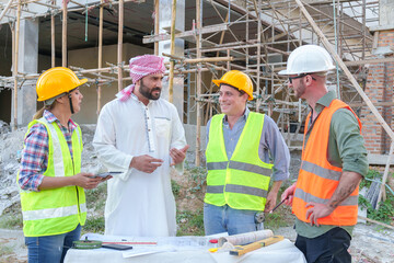 Diverse team of professionals using tablet computers on construction site. Real estate construction...