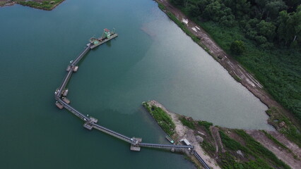 Aerial view of floating dredgers operating in a flooded sand quarry, showcasing industrial mining...