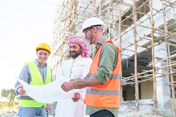 Diverse team of professionals using tablet computers on construction site. Real estate construction project. with civil engineers, architects, Arabic business investors and explorer with theodolite