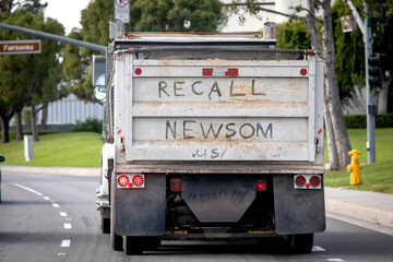 A handwritten sign on the back of a truck stating recall Newsom