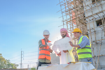 Diverse team of professionals using tablet computers on construction site. Real estate construction project. with civil engineers, architects, Arabic business investors and explorer with theodolite