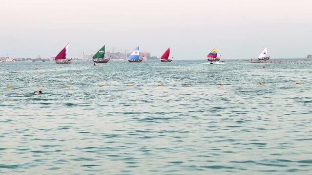 Qatar Morocco Argentina Ecuador Korea Saudi Arabia with Al Nassr in football Asia in a frame of traditional boat sailing in the sea a man is swimming in the scene scenic background of sunset and tower