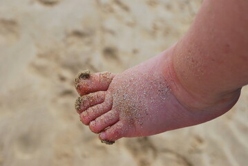  Baby foot on sand beach in the summer
