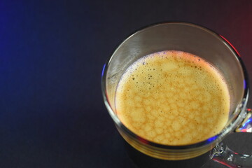 hot black coffee on black table with neon lights