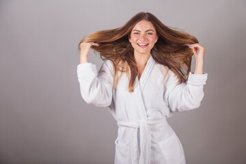 Brazilian blonde woman showing wonderful hair. Wearing a bathrobe. Messing with hair, hair with...