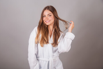 Brazilian blonde woman showing wonderful hair. Wearing a bathrobe. Messing with hair, hair with...