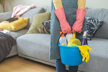 Tired household clean up, housekeeper asian young woman, girl in apron, hand holding bucket of...
