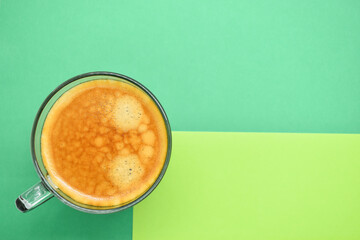 glass of hot black coffee put on green background