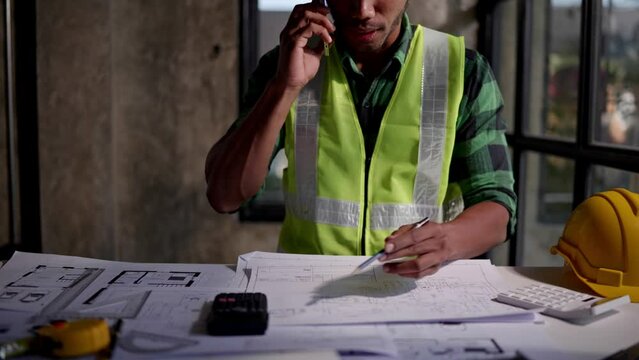 Close up of hands working and calculations estimate for cost and materials planning on paperworks and floor plan drawings about design architectural and engineering for houses and buildings.