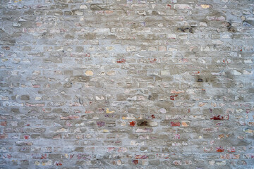 Background from a gray brick wall with with some plaster on it