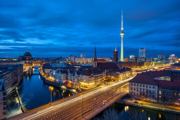 The center of Berlin with the famous TV Tower and a clouded sky at night