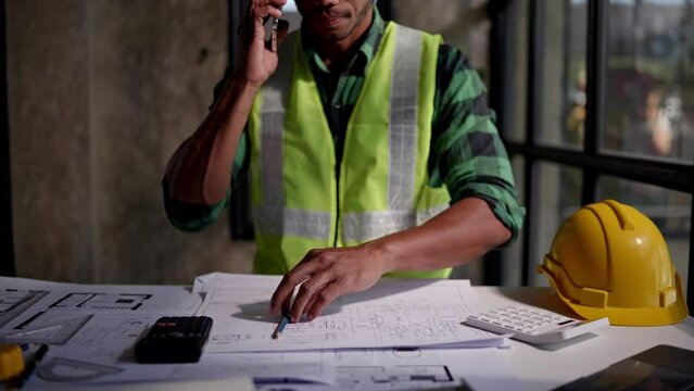 Close up of hands working and calculations estimate for cost and materials planning on paperworks and floor plan drawings about design architectural and engineering for houses and buildings.