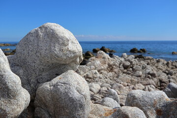 Fototapeta na wymiar Large white granite boulder on the beach