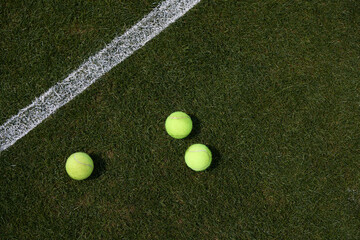 tennis balls on a grass tennis court