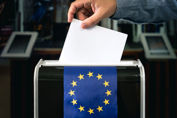 man putting ballot in box during elections in europe. copy space, flag of europe