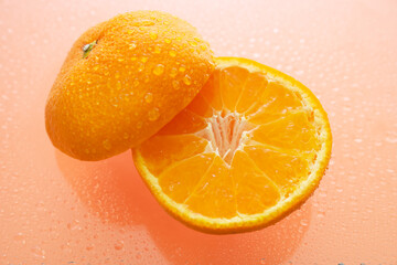 オレンジ色の背景でみかん（オレンジ）を撮影した写真