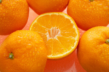オレンジ色の背景でみかん（オレンジ）を撮影した写真