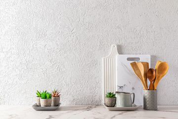 modern design of the kitchen countertop in a minimalist style. beautiful kitchen utensils on a countertop against a gray textured wall. a copy space.