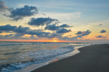 Sunset on a beach in Acapulco, Pie de la Cuesta beach, sun setting to the horizon in Mexico