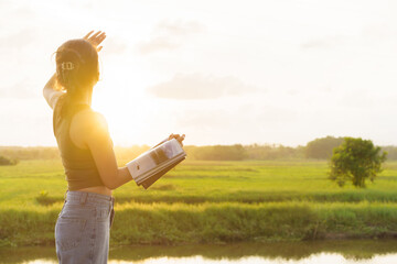 Woman holding book looking at sunrise in morning